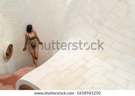 Top view of a young dreamy Caucasian woman in a bikini gazing into the distance