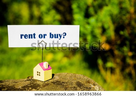 Miniature House Model On stone With Question Marks Over nature background.Make the right decision. Real estate concept. Rent apartment. Property. Rental, renting home. Rent or buy. Purchase housing