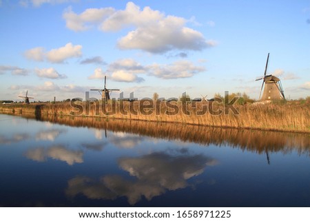 Molenlanden, Netherlands - Windmills across and reflected in water at famous tourist site Kinderdijk in Holland. UNESCO World Heritage.
