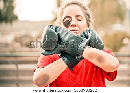Female activist with a boxing gloves, demonstrating violence on women. Woman protesting against domestic violence and abuse. Violence and protest concept - Image