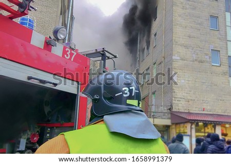firefighter in front of a fire in a high-rise trade building, fighting fires in a big city.