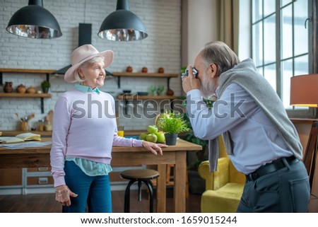 Home photoset. An elderly man taking pictures of his wife