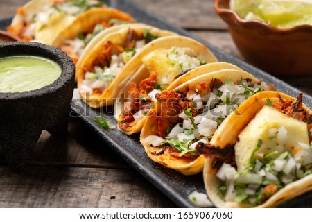 Traditional mexican pork tacos called "Al pastor" with pineapple on wooden background
