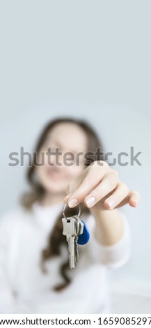 The image of a European woman with keys in her hand. Handing over keys to real estate, rent, sale, purchase.