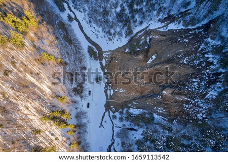 Amazing aerial view of forests and a road in winter time seen from drones