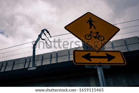 Foot and bike path sign under a bridge