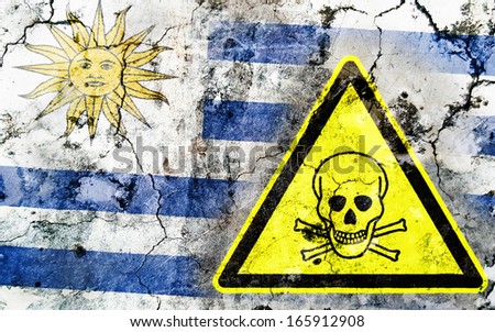 Old cracked wall with poison warning sign and painted flag, flag of Uruguay