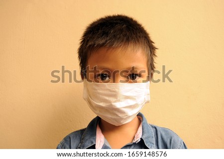 Asian boy using medicine healthcare mask for health medical care, protect Covid-19 and Air pollution pm2.5.