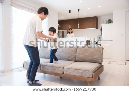Father playing with child in living room Royalty-Free Stock Photo #1659217930