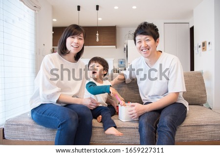 A family of three relaxing in the living room Royalty-Free Stock Photo #1659227311