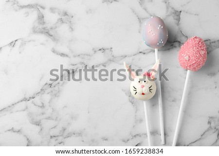 Delicious sweet cake pops and space for text on white marble table, flat lay. Easter celebration