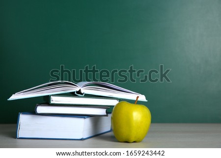 Apple and stack of books on white wooden table, space for text. Doing homework