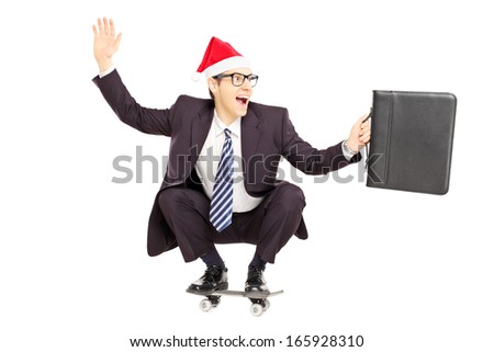 Young smiling businessperson with briefcase and santa hat on a skateboard isolated on a white background