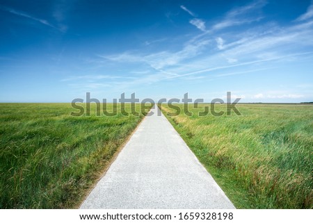 Long straight road along grassland Royalty-Free Stock Photo #1659328198