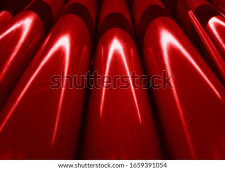 Dramatic light reflections on red construction pipes