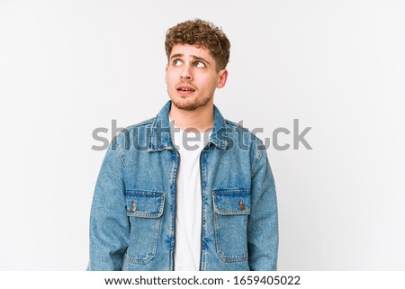 Young blond curly hair caucasian man isolated confused, feels doubtful and unsure.