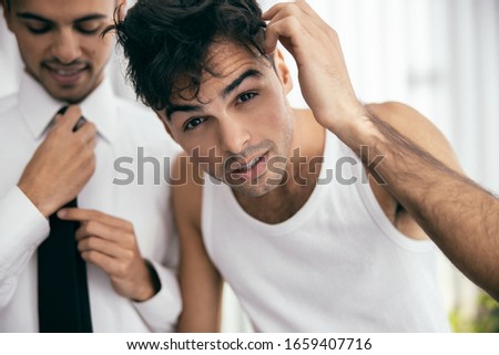 Close up of twins standing and looking in the mirror early in the morning stock photo