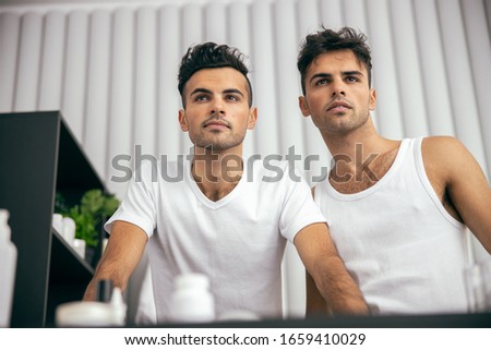 Twins wearing white t-shirts and staying at home stock photo
