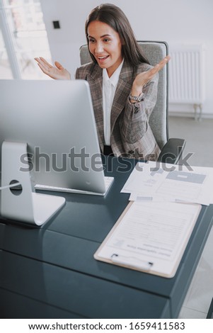 Smiling businesswoman looking on computer at workplace stock photo