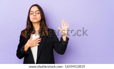 Young mixed race hispanic woman isolated taking an oath, putting hand on chest.