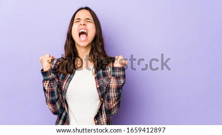 Young mixed race hispanic woman isolated raising fist after a victory, winner concept.