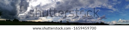 Widescreen of blue sky with clouds and landscape