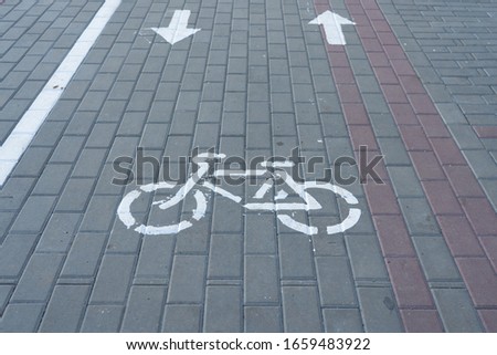 white bike road sign painted on asphalt