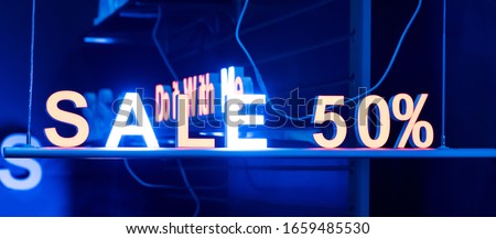 neon sign sale in the shop window at night on the street, cyber Monday and black Friday sale concept