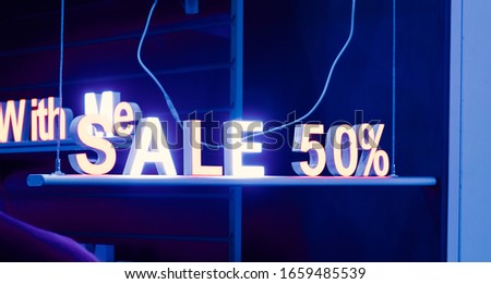 neon sign sale in the shop window at night on the street, cyber Monday and black Friday sale concept