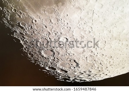 The moon and its craters in the night sky.