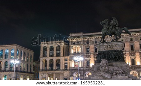 Vittorio Emanuele II statue at Piazza del Duomo timelapse at night. Milan in Lombardy, Italy. Museum on background. Summer day