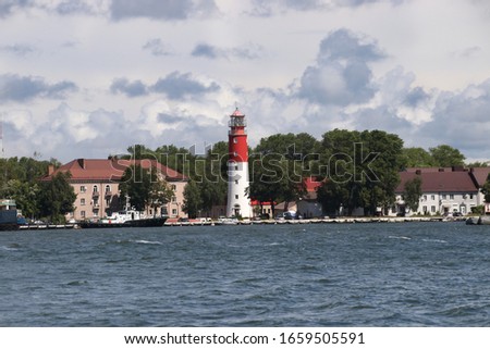 Red and white lighthouse in Baltiysk, Kaliningrad region. Russia Bay in the foreground Royalty-Free Stock Photo #1659505591