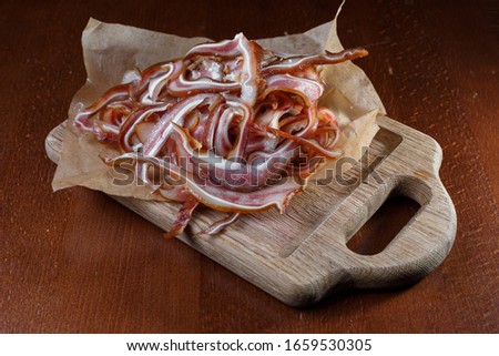 Pig ears on parchment on a wooden stand.