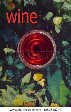 
Glass of red wine on a colorful picturesque background and the text "Wine"