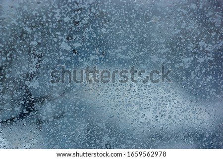 water drops on the frozen fogged glass of the car