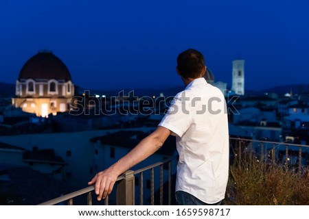Firenze or Florence, Italy historic city with famous architecture church duomo in summer evening sunset night cityscape skyline and young man back on rooftop