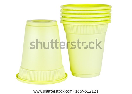 Upside down one and standing five in set unused green disposable cups made of biodegradable materials isolated on white background