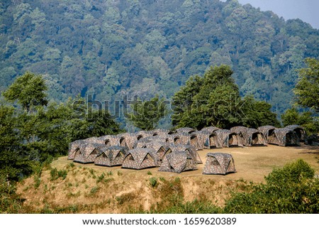Tourist tents camping among meadow on mountain in Thailand