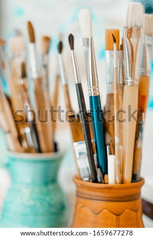 Tools and equipment for the artist. Palette and brushes close-up. The process of drawing and creativity. The picture is in blue