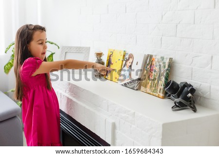 Little girl holding canvas in the interior