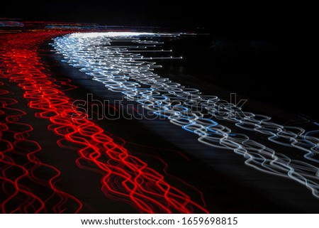 Digital red and white waves of light on beach