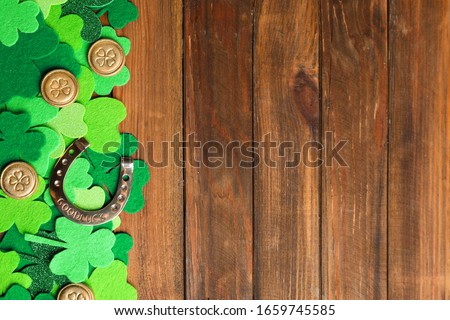 Flat lay composition with horseshoe on wooden background, space for text. St. Patrick's Day celebration