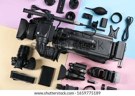 Flat lay composition with video camera and other equipment on color background