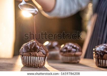 Close up of hot chocolate pouring over a delicious, tasty cupcake
