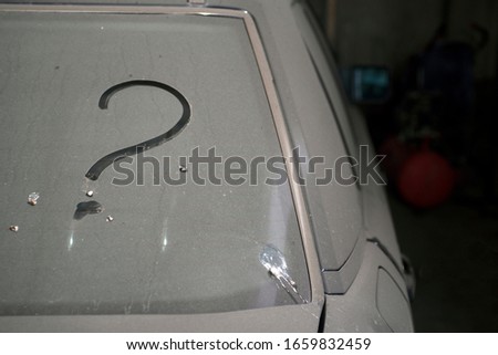 A question mark on the window of a dirty, unwashed car.