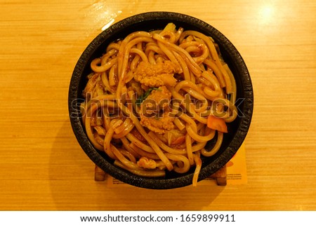 Selective focus picture with grainy effect of special black pepper spicy udon from Japanese restaurant.