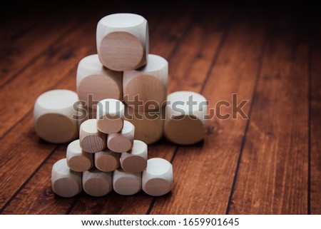 The wooden natural cubes with rounded corners on a brown wooden backgraund.
