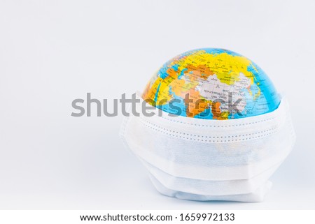Surgical Face Mask and Globe model. Coronavirus Concept. Medical Face Mask For Stopping The Spread of Flu Virus. Surgical mask with rubber ear straps. Standard surgical mask to cover the mouth and nos