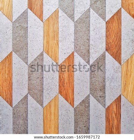 Gray ceramic tile with geometric pattern for wall and floor decoration. Concrete stone surface background. Texture with wooden fragments for interior design project.