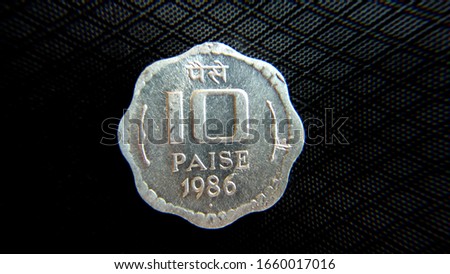 top view of Indian old ten paise coin isolated on black texture